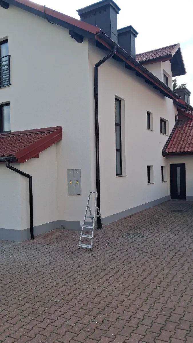 Drabina przy elewacji domu podczas montażu rynien