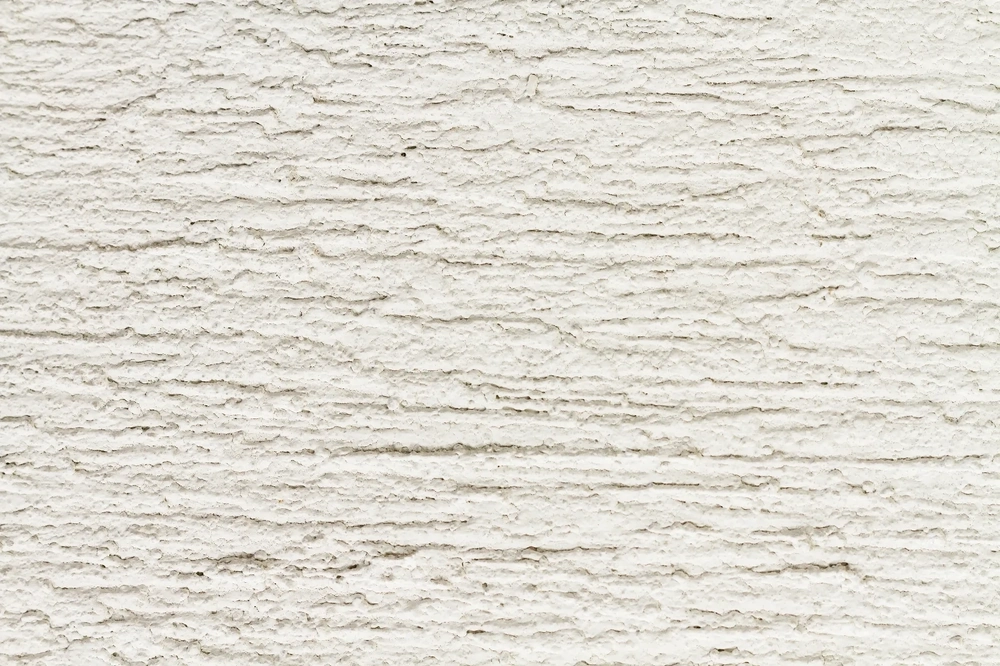 Zbliżenie białej ściany wykończonej tynkiem dekoracyjnym strukturalnym Tynkowanie dekoracyjne