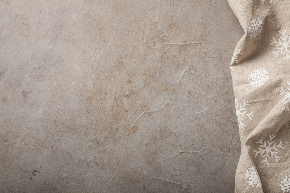 Beżowa ściana z subtelną fakturą i dekoracyjnym materiałem w białe płatki śniegu