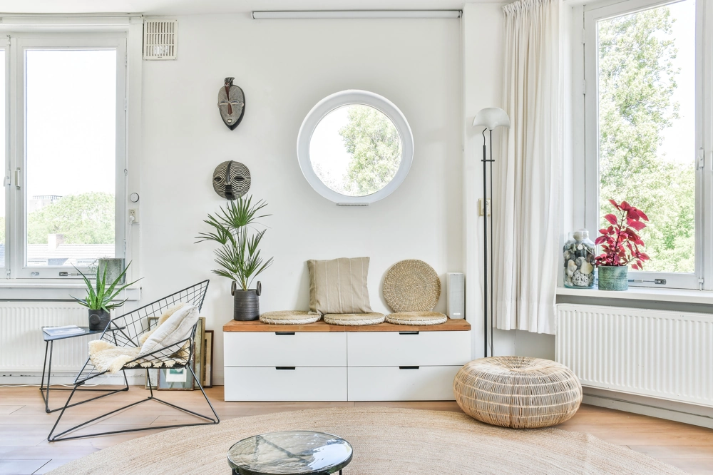 Nowoczesne jasne wnętrze z siedziskiem, roślinami i lampą stojącą – aranżacja wnętrz