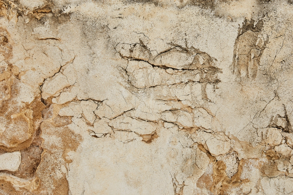 Popękany, dekoracyjny tynk na ścianie będący przykładem usługi Tynkowanie dekoracyjne